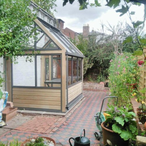 narrow wooden lean-to greenhouse